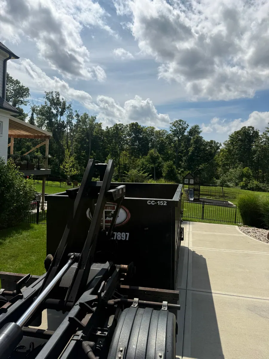 Clutter Cleanout 15 yard dumpster CC-152 delivered by roll-off truck to a concrete driveway in Anderson Township, OH