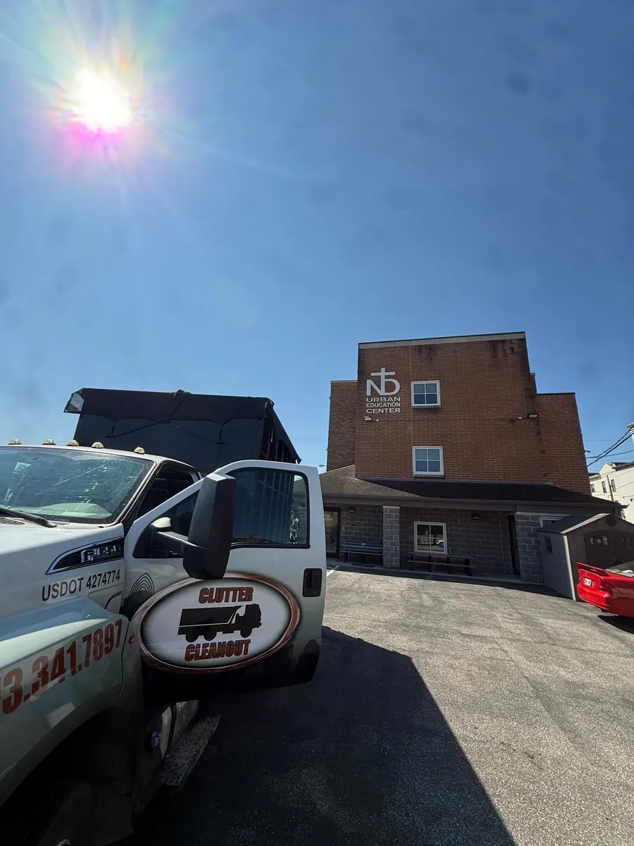 Clutter Cleanout roll-off truck with a loaded 20 yard dumpster on a job in Covington, KY