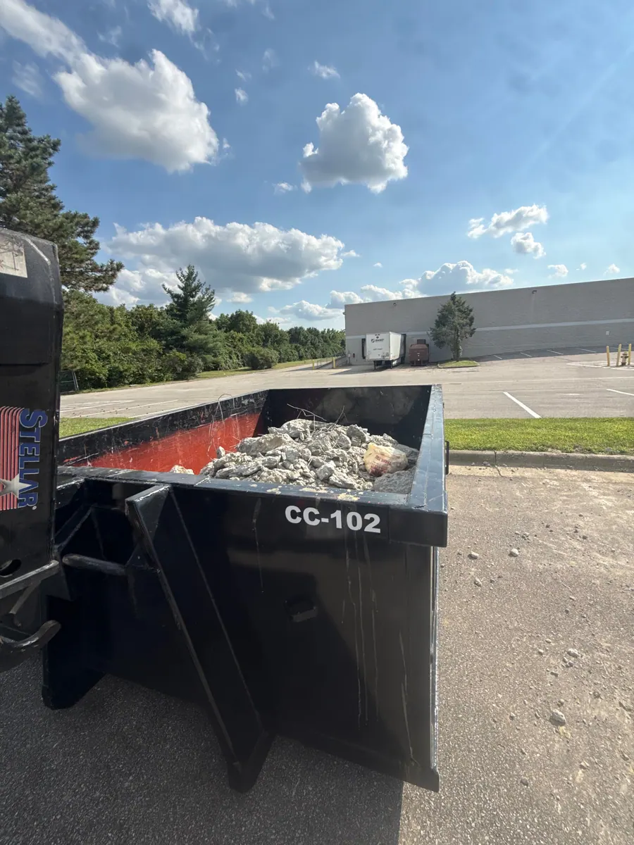 Clutter Cleanout 10 yard dumpster CC-102 loaded with broken concrete on a Florence KY commercial lot