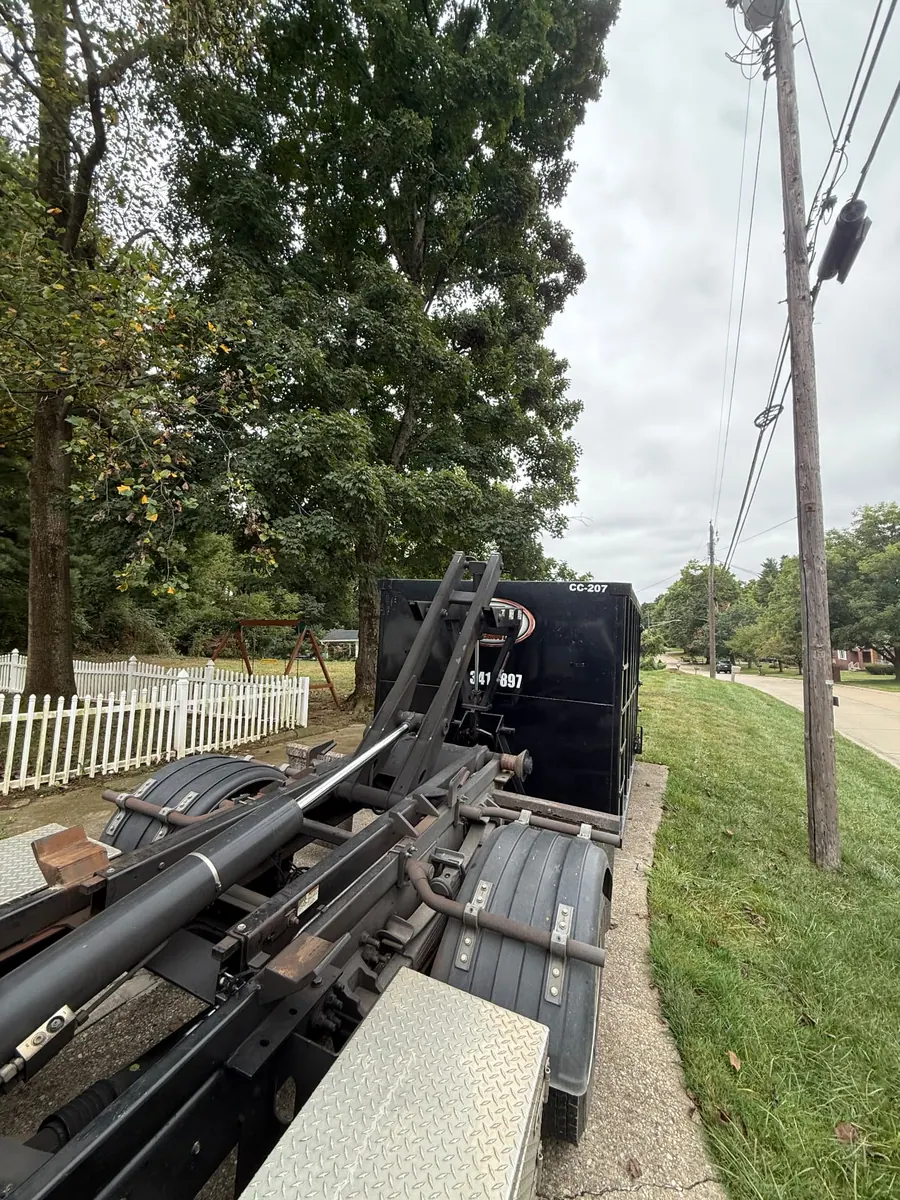 Clutter Cleanout 20 yard dumpster CC-207 delivered by roll-off truck beside a residential street in Fort Mitchell, KY