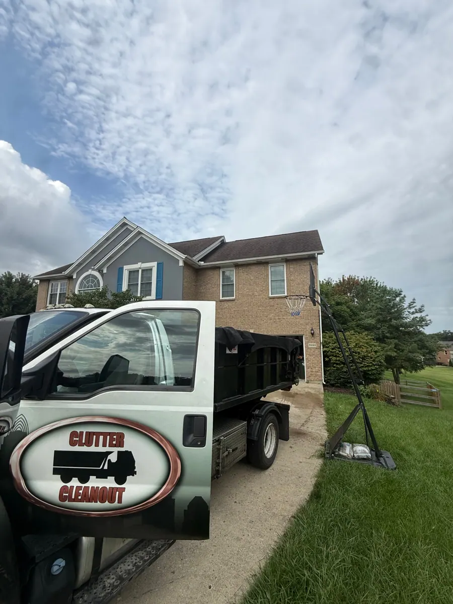 Clutter Cleanout roll-off truck delivering a 10 yard dumpster to a West Chester OH driveway for a home cleanout