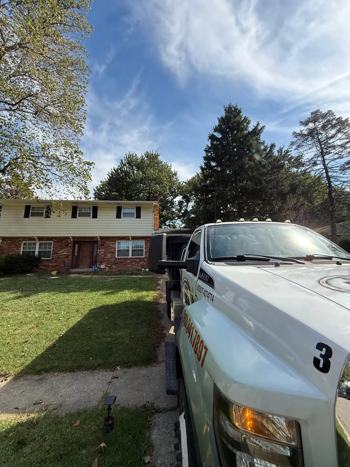 Clutter Cleanout 10 yard dumpster delivery truck on a residential driveway in Anderson Township, OH