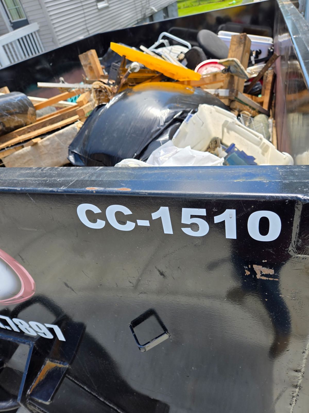Top-down view of loaded 15-yard dumpster CC-1510 packed with furniture, wood, and household debris from an Alexandria, KY cleanout