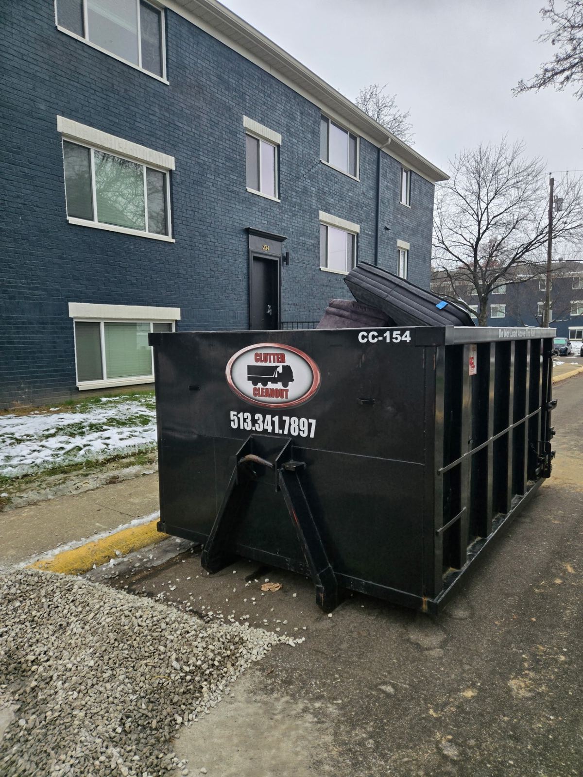 15-yard Clutter Cleanout dumpster rental at an apartment complex in Alexandria, KY loaded with furniture and debris