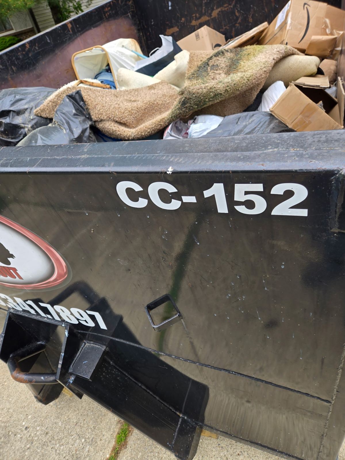 Loaded 15-yard dumpster CC-152 filled with old carpet, cardboard, and bagged household debris from an Amelia, OH cleanout
