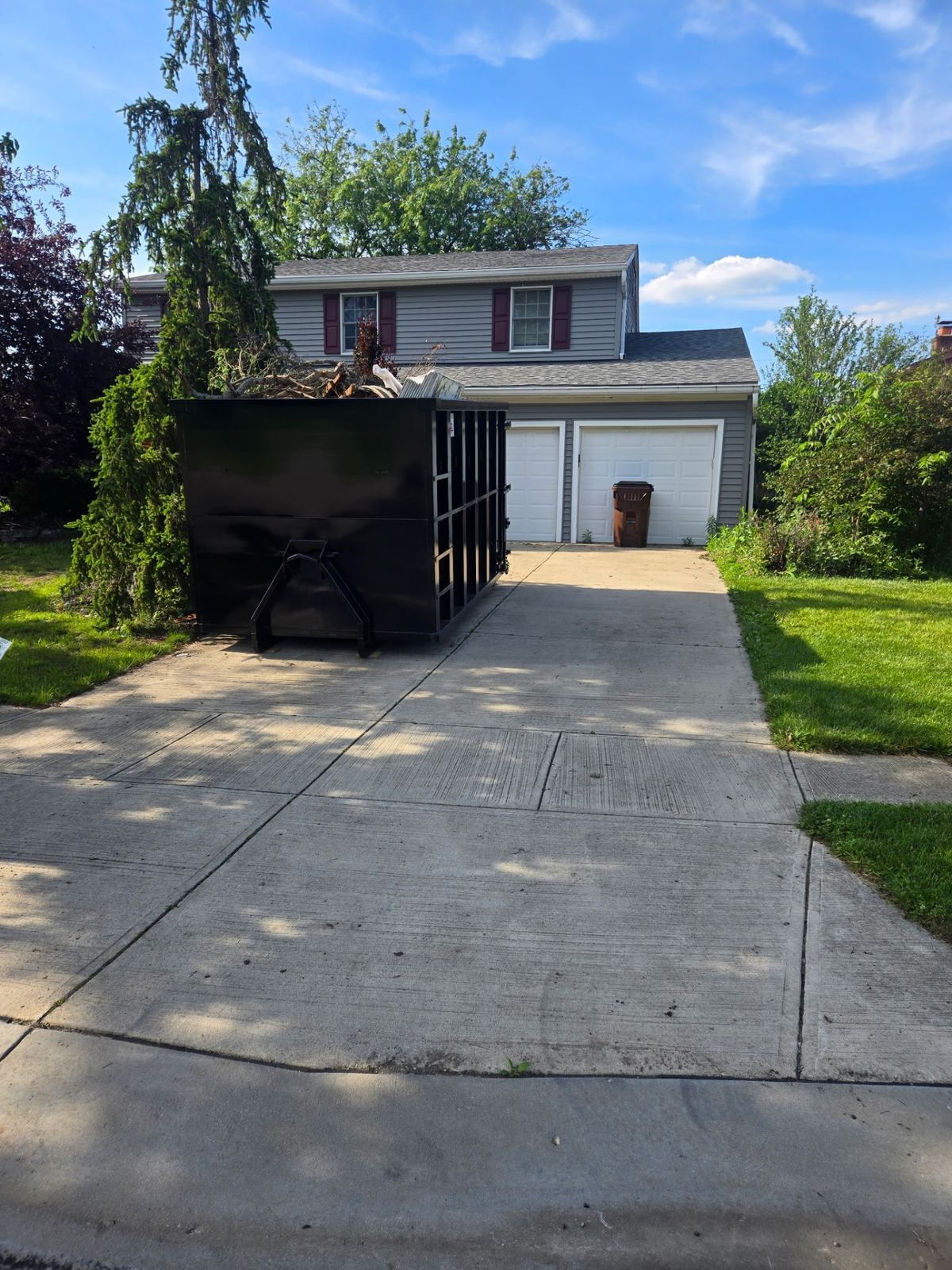 Clutter Cleanout 20 yard dumpster loaded with cleanup debris on a residential driveway in Amelia OH