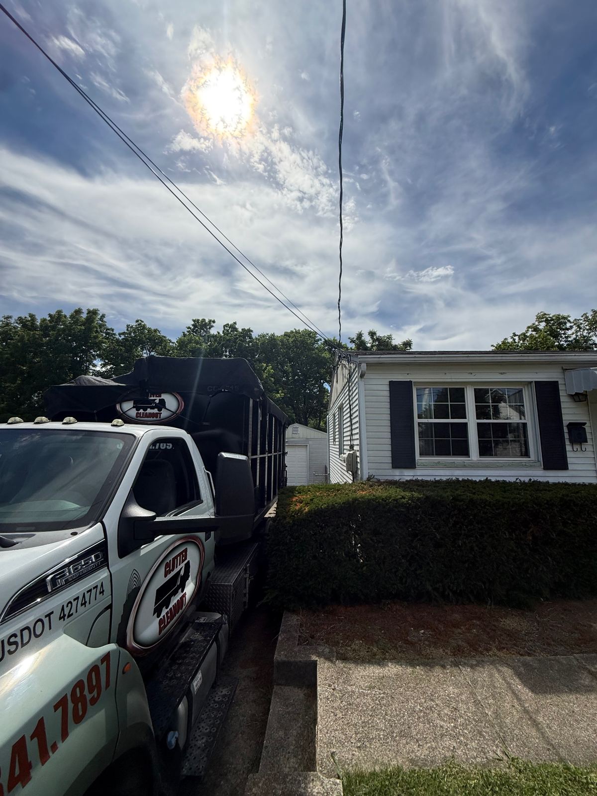 Clutter Cleanout F-550 truck delivering a 15 yard dumpster CC-1515 to a Blue Ash OH driveway