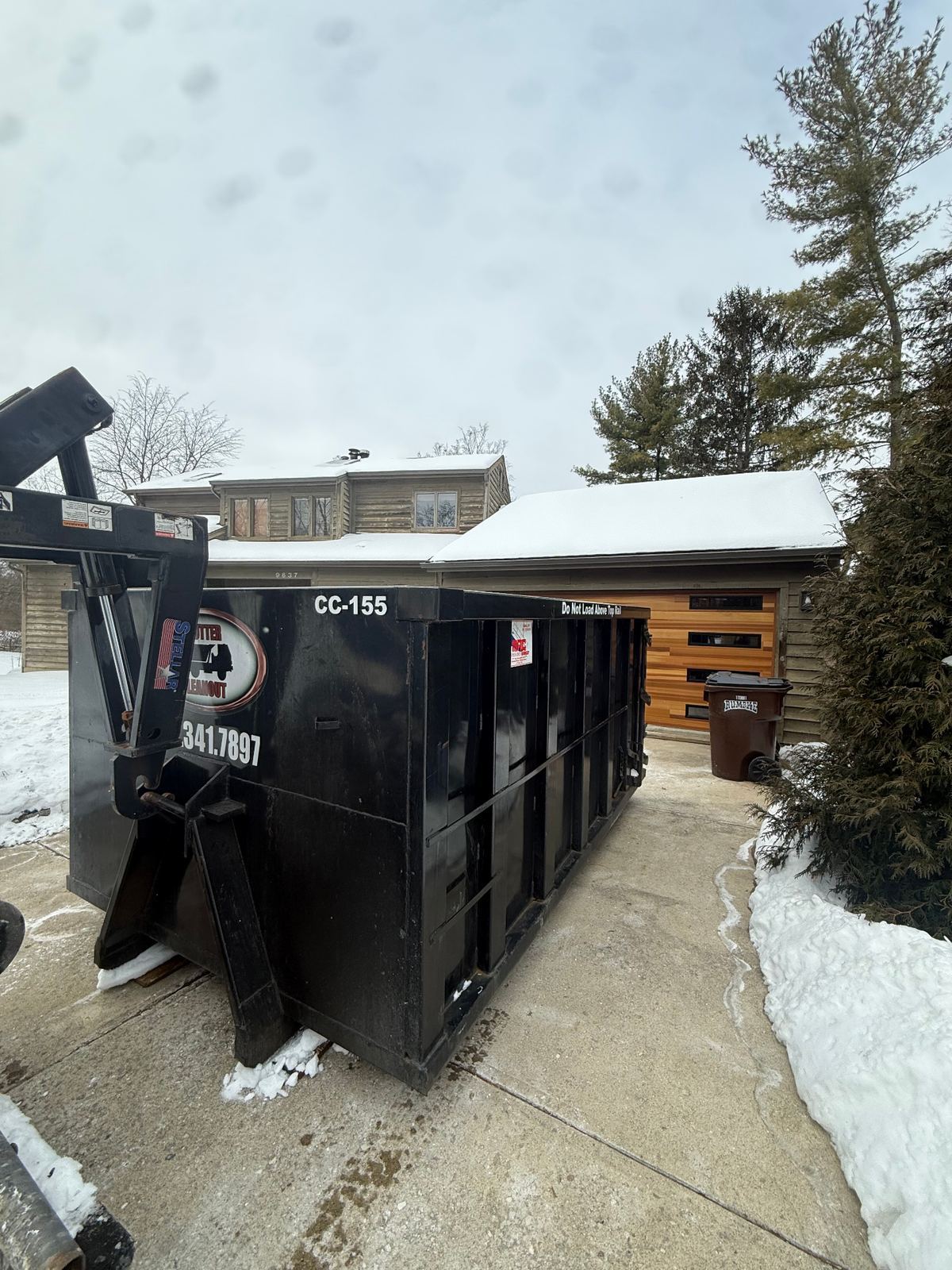 Clutter Cleanout dumpster CC-155 delivered to a snowy driveway for a home cleanout in Blue Ash OH