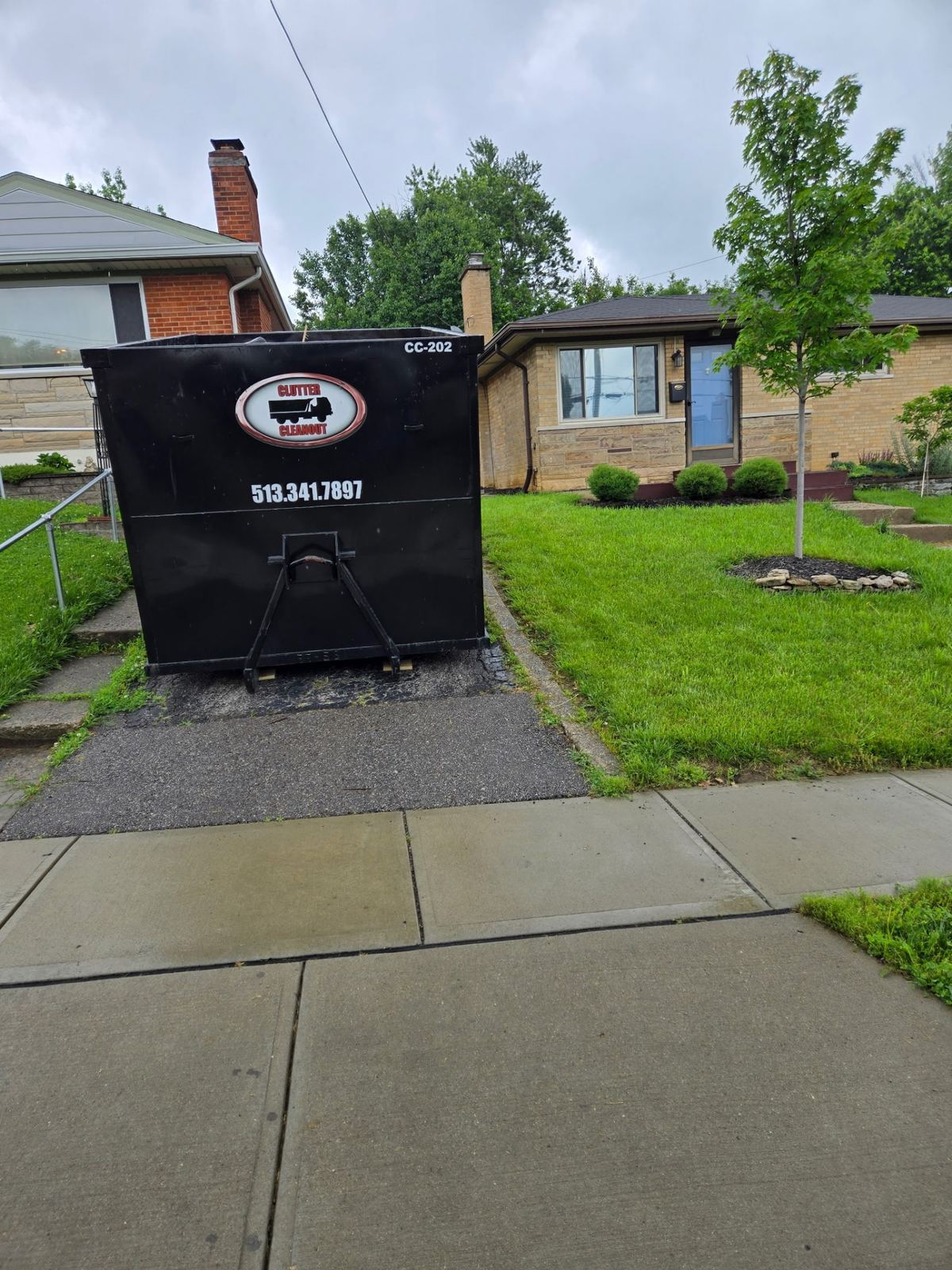 Clutter Cleanout 20 yard dumpster CC-202 placed on a Blue Ash OH driveway in front of a ranch home