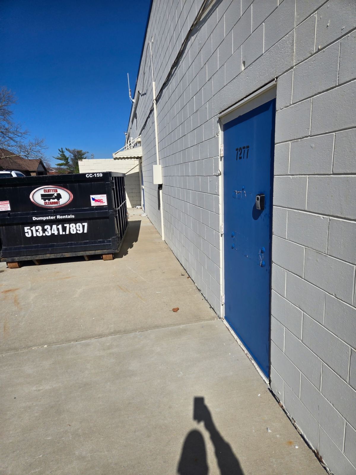 Clutter Cleanout dumpster rental placed behind a commercial property in Florence, Kentucky