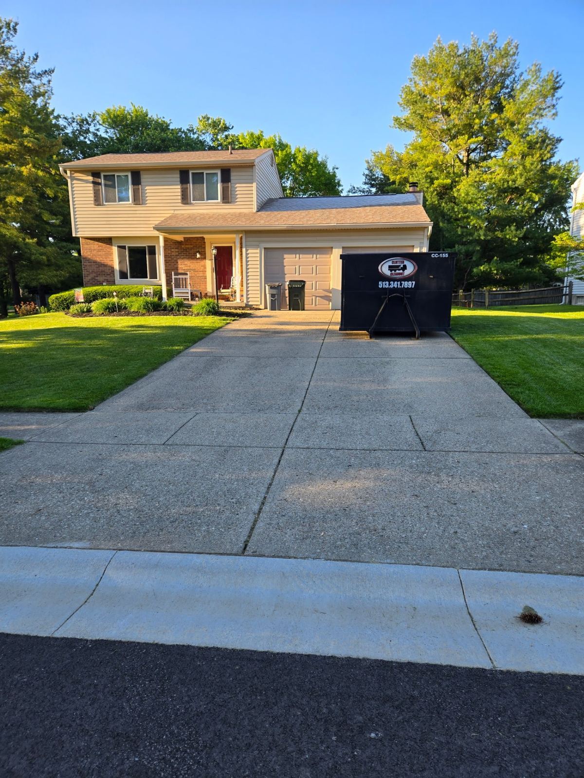 15-yard Clutter Cleanout dumpster CC-155 placed on a driveway in front of a two-story home in Florence, KY for a garage cleanout