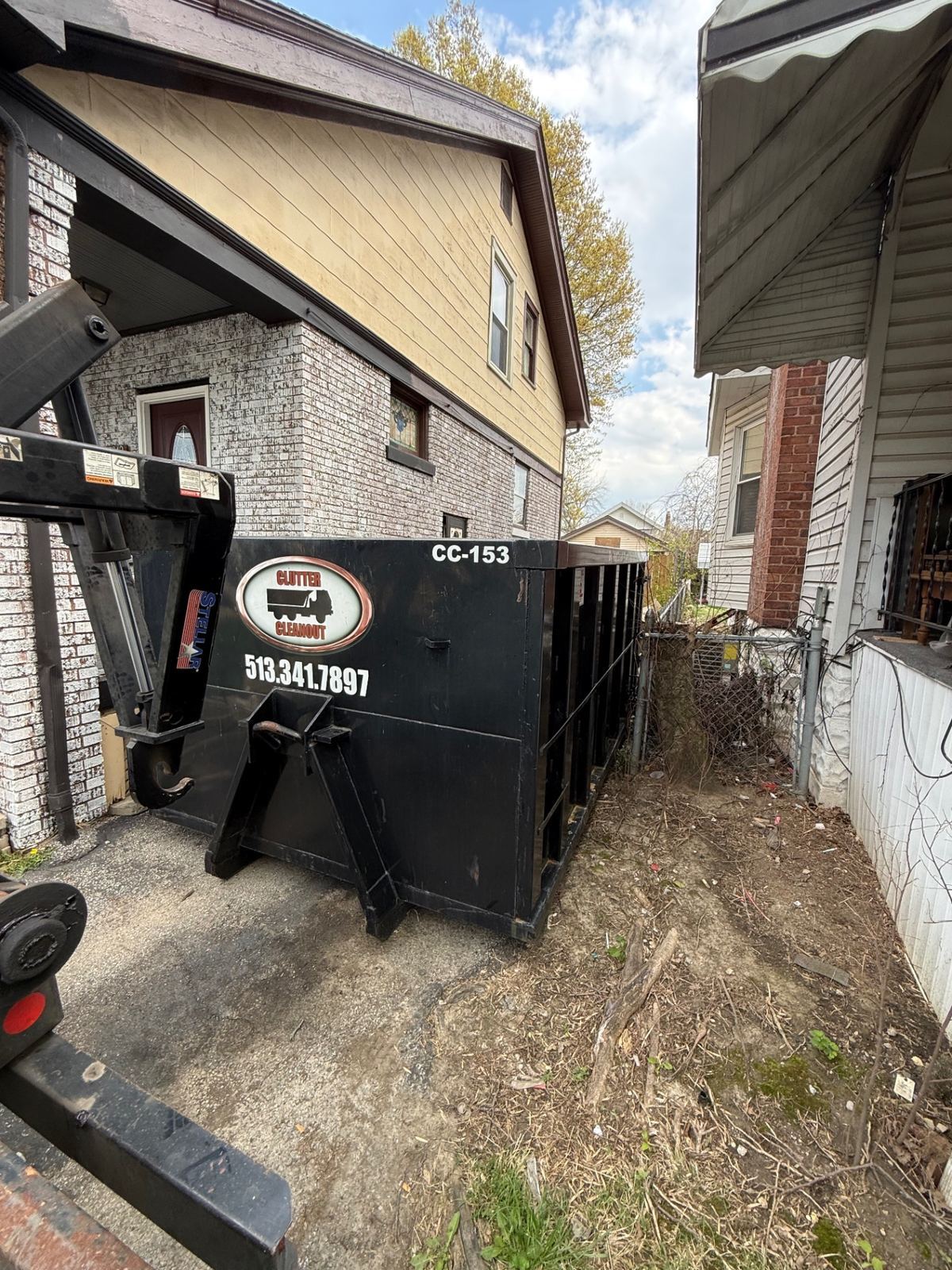 Dumpster rental in Loveland OH driveway for garage cleanout with boxes and household items
