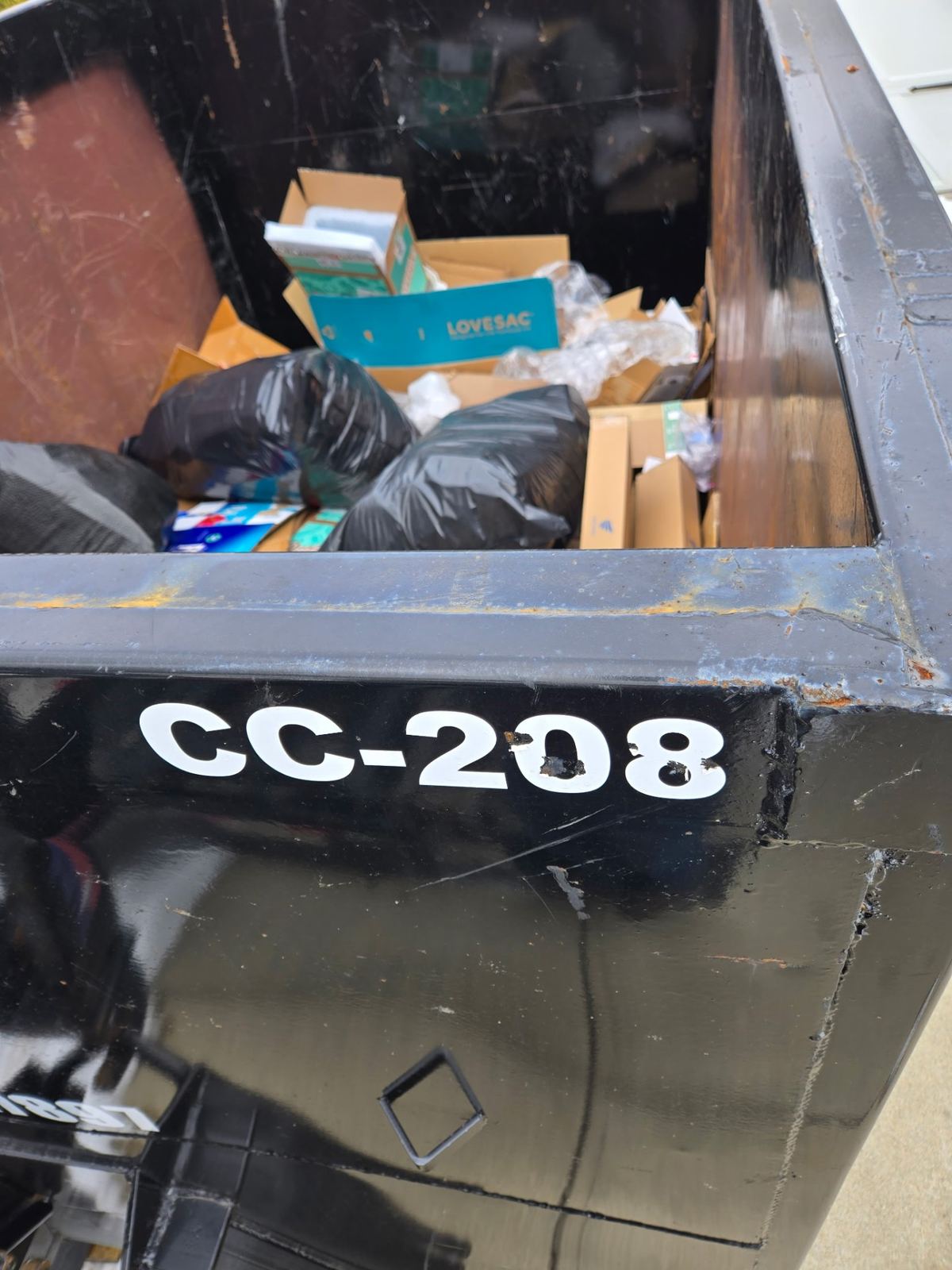 Close-up of Clutter Cleanout dumpster CC-208 loaded with boxes and trash bags during Madeira OH cleanout