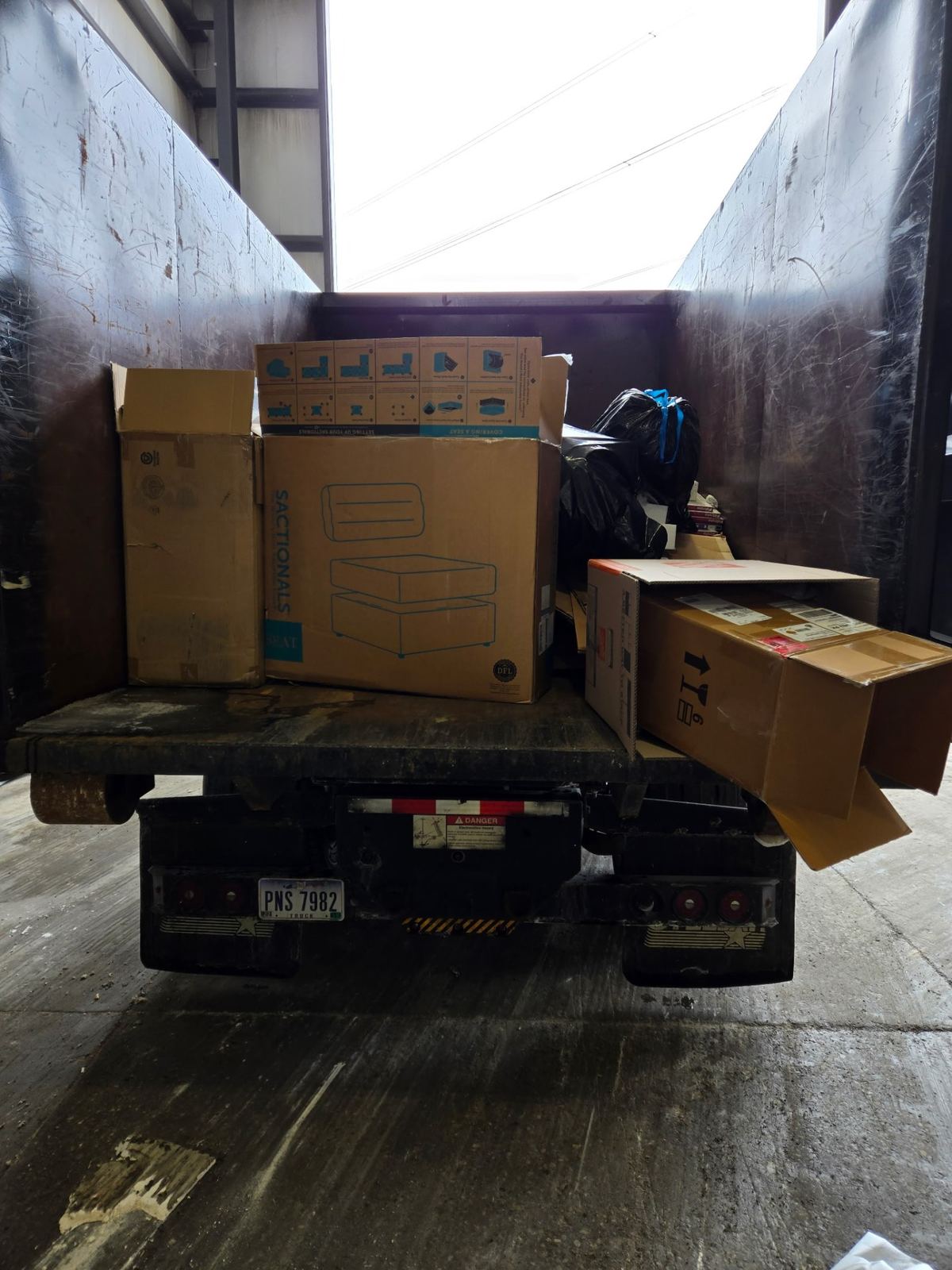 Dumpster loaded with furniture boxes and household items from a Madeira OH cleanout project