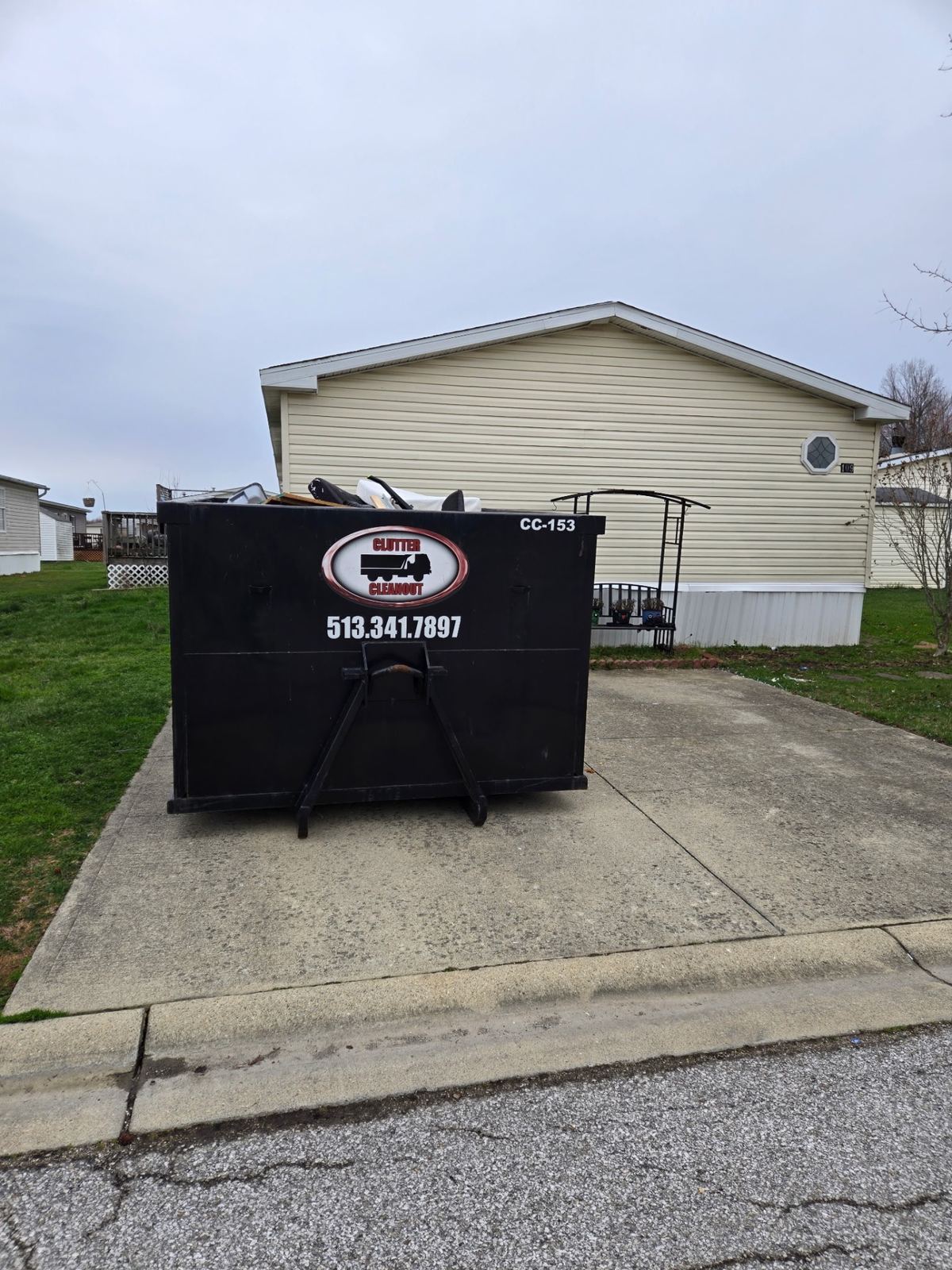 Clutter Cleanout 15-yard dumpster CC-153 on a driveway in Newport, KY loaded with household cleanout items