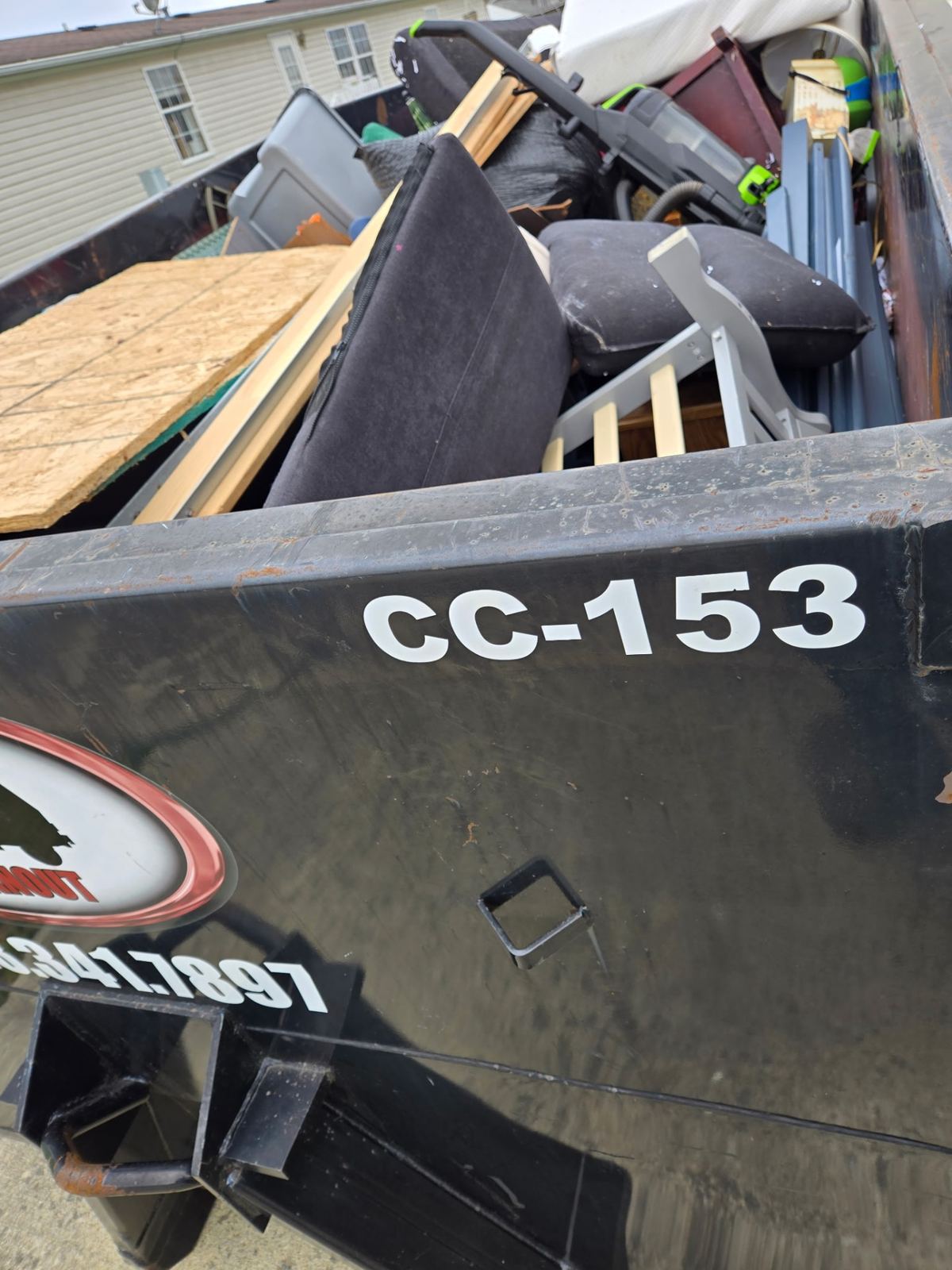 Close-up of dumpster CC-153 packed with furniture, plywood, and household junk from a Newport, Kentucky cleanout