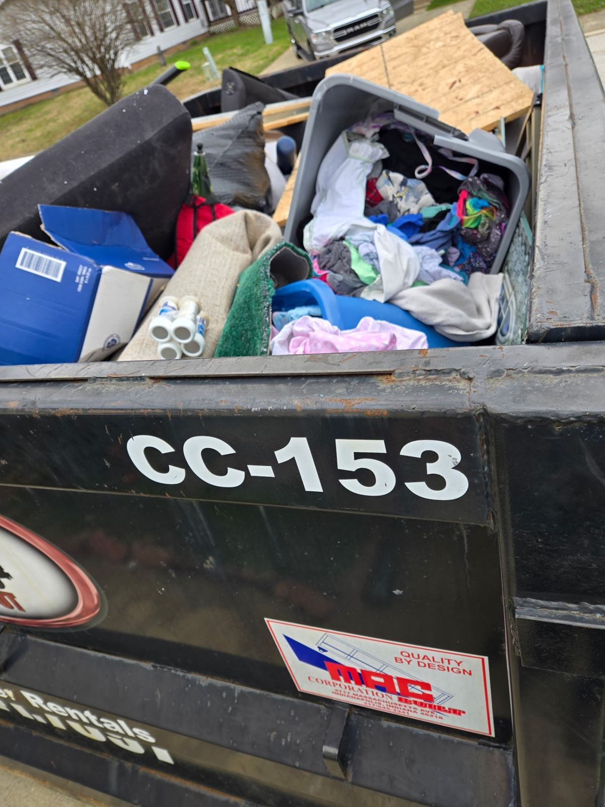 Overhead view of dumpster CC-153 filled with clothes, carpet, and household debris in Newport, KY