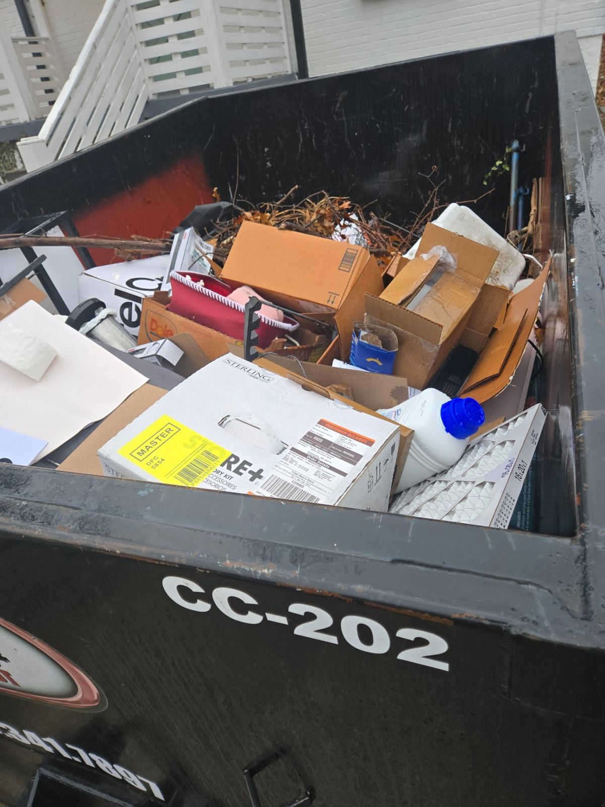 Close-up of Clutter Cleanout dumpster CC-202 loaded with household junk during Norwood OH cleanout