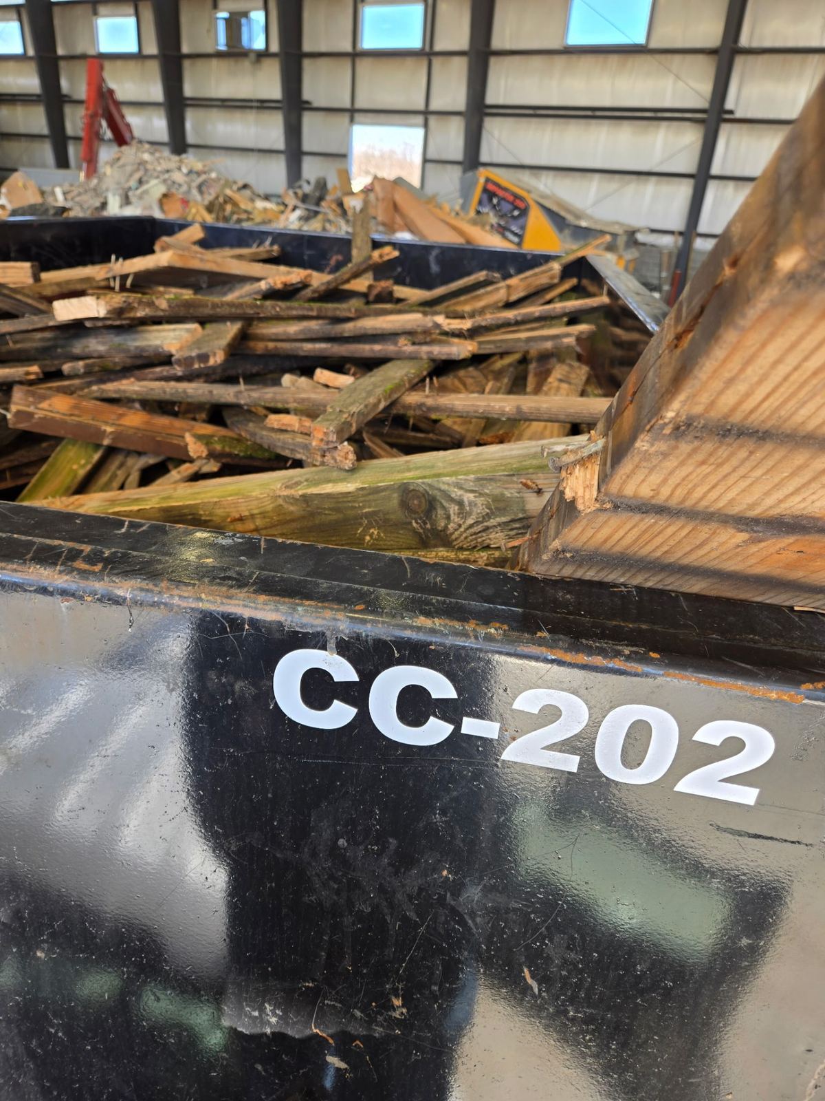 Close-up of Clutter Cleanout dumpster CC-202 loaded with construction lumber and debris from Oakley OH renovation