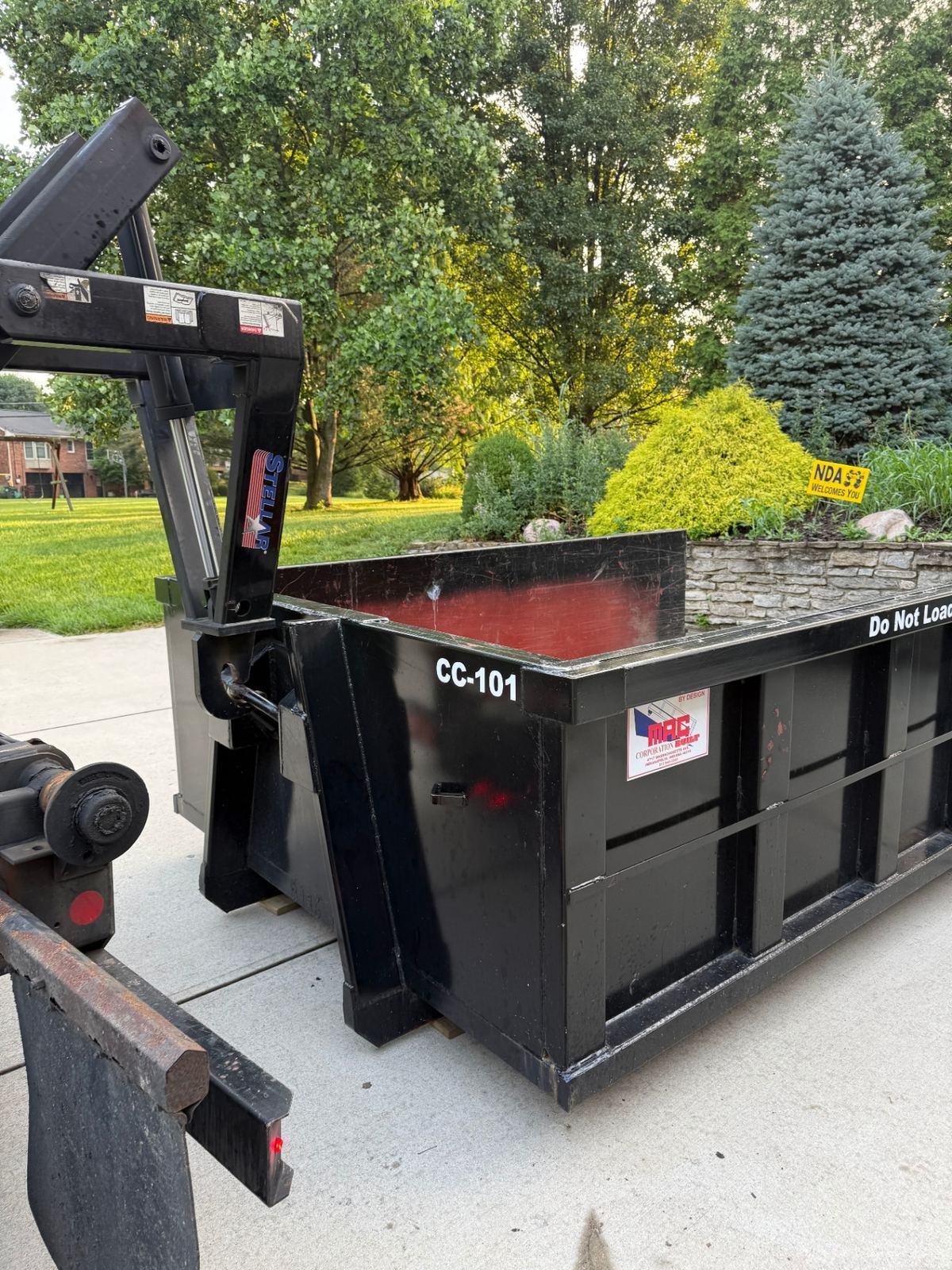 Clutter Cleanout 10 yard dumpster CC-101 being delivered to a Villa Hills KY driveway next to a landscaped front yard