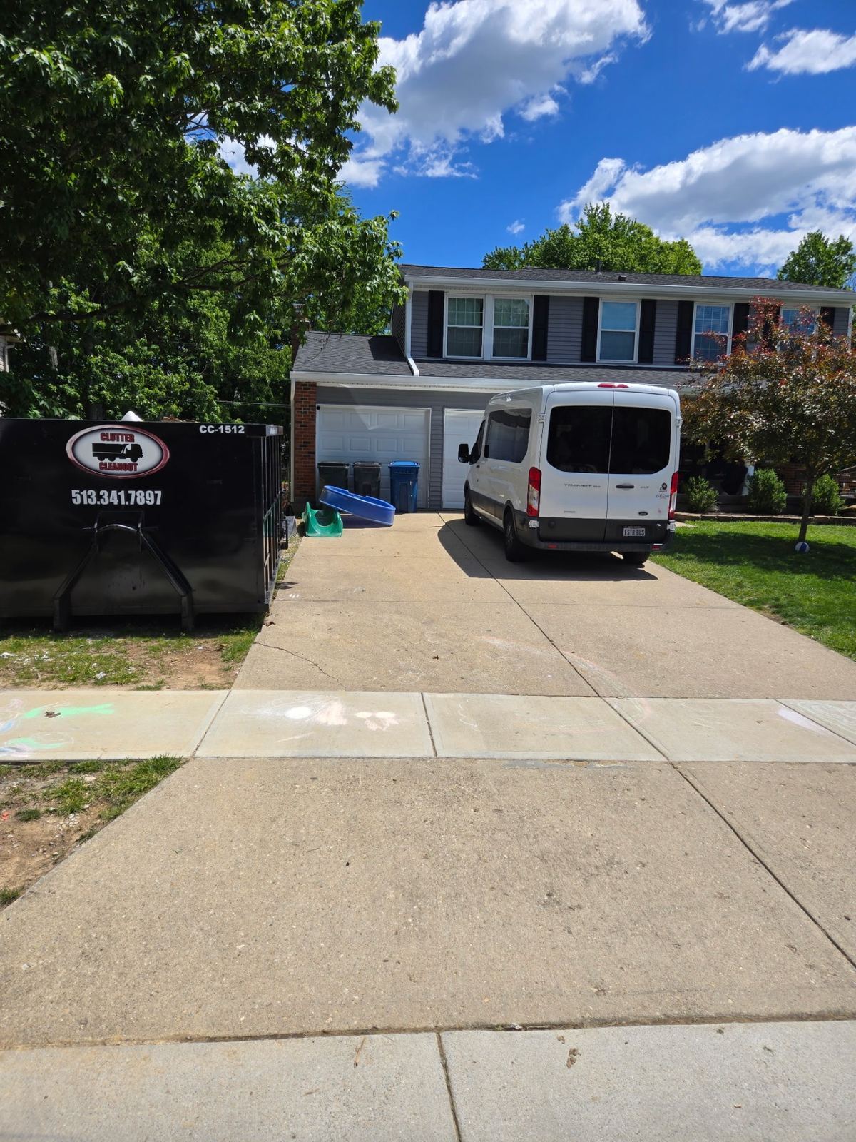 15-yard Clutter Cleanout construction dumpster CC-1512 placed on a residential driveway in West Chester, OH next to a contractor van